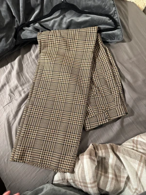 Högmidjade rutiga byxor  - Ett par högmidjade rutiga byxor från Monki i storlek 38. På sista bilden syns samma byxor fast i ett annat mönster för att bättre se hur de sitter på 😇