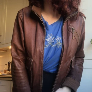 Brun läder jacka - Inte äkta läder!! Säljer denna super snygga jacka i brunt veganskt läder. Tidigare köpt på plick, men knappt använd. Toppen skick och håller en varm. 