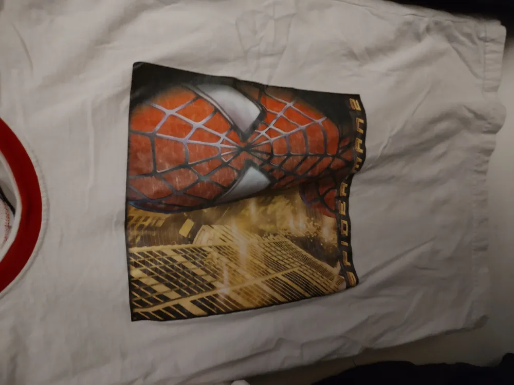 En vit tshirt med Spiderman tryck.. T-shirts.