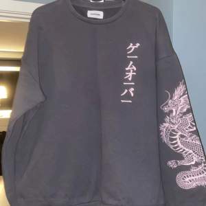 Mörkgrå sweatshirt med ljusrosa tryck. Storlek M. 200 kr + fraktkostnaden. Pris kan diskuteras. 