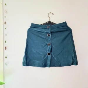 Grön kjol mango - Stretchig latex-liknande material. Stora knappar på framsidan 🌳