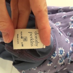 Supersöt sommarklänning - Superfin blommig lila klänning, perfekt för sommaren! Stl 40, passar M men passar även S om man vill att den ska sitta lite lösare. Ända anmärkningen är att axelbanden är knutna, annars väldigt gott skick.