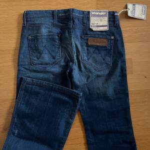 lågmidjade bootcut jeans från wrangler, helt oanvända med lappen kvar! skulle chansa på att de är från tidigt 90-tal :) midjemåttet är runt 73cm och innerbenslängden är 77cm. orginalpris: 999kr. köparen står för frakten <3