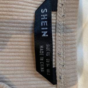 Ett kort linne från SHEIN. Köpt för några år sedan och använder inte längre. Den har en smuts rosa färg med tunt material. Den är även ganska kort, Den är i storlek Xs men passar även S