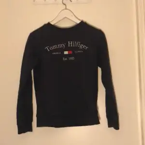 Säljer en mörkblå Tommy Hilfiger tröja något liten i storleken. Sparsamt använd. 
