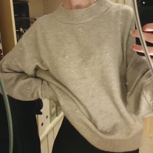 Mysig tröja med pärlor på - Grå mjuk tröja med vita pärlor på. Har använt max 5 gånger. Köpt på H&M. Köparen står för frakten. Skriv om du har frågor ❤️