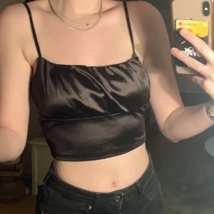 topp - skit fin glansig mörk brun topp som jag hållt kärt ett tag men som jag inte längre gillar hur den sitter på mig. skick som ny<3 (axelband som går att ändra)