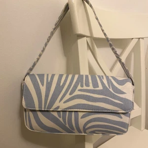Handväska  - Säljer min vit/blåa handväska ifrån Gina Tricot, väldigt sparsamt använd, 2-3 gånger max 🥰