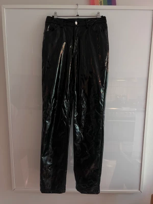 Lack byxor Nelly Trend Svarta Strl 34 - Fantastiaka lackbyxor från nelly trend, strl 34.  Stretchiga och passar upp till 38/40 ca.  Mycket sparsamt använda och i toppskick.   Finns att hämta i Midsommarkransen alt skickas spårbart á 66kr. 