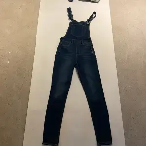 Oanvända hängselbyxor i mörk jeans färg. Super fina!  Köparen står för frakten. Jag visar bild när jag skickar paketet. Vid fler intressen av kläderna kan bud läggas