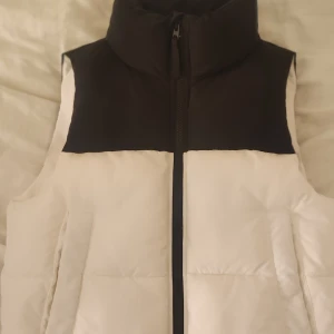 Puffer väst - Svart-vit croppad dunväst från gina tricot, använd nån gång bara, strl 146-152, passar nån i xs också🤍