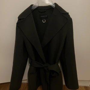 Stockh lm kappa - En snygg kappa av ullmix inne lyxig grön färg. Köptes för 1500kr. Säljs för 800kr ( helt slutsålda) Använt 4-5 gånger, i jättebra skick.