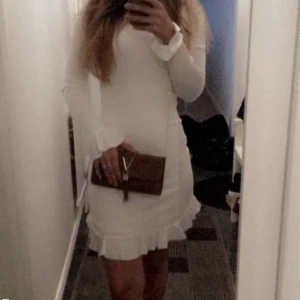 Vit kort klänning  - Tight vit klänning med volanger i armarna och nertill. Använd en gång. 