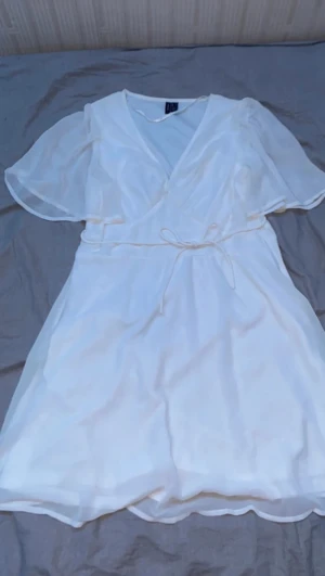 Vit vero Moda klänning - Helt ny klänning från Vero Moda andvänd till endast ett tillfälle jätte skön och inte genomskinlig endast vid ärmarna dragkedja vid sidan med v-ringning Perfekt till midsommar eller skolavslutning men även till mycket annat Kontakta mig för fler bilder