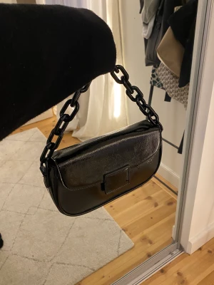 Väska  - Snygg svart lack väska från Gina tricot.