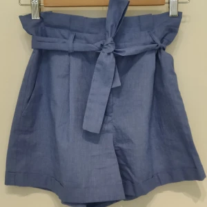 Fantastiska lavendelblå shorts med pressveck, hög midja och knytskärp. - Material 65% polyester, 35% bomull  Använda 2 gng, säljes då de är lite för små ☹️ Kan posta via skicka lätt om det finns intresse. 