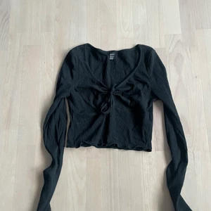 Svart tröja  - Svart tröja med knytdetalj där fram  Stl: XS  Pris: 30 kr  