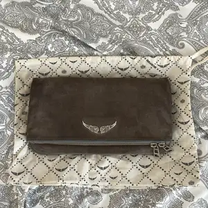 Zadig Voltaire Rock Clutch in gray suede and silver metal details. Bought in 2018 used several times but still in very good condition. Two straps one long and one shorter. 4 different compartments. Comes with dustbag.