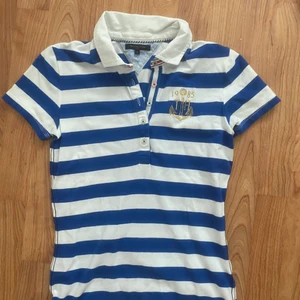 Pike Tommy Hilfiger - En blåvit randig kortärmad pike från Tommy hilfiger. Bra skick.
