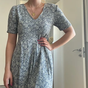 Lång sommarklänning  - Längre sommarklänning i blommönster. Ca storlek 38-40, ganska flowy med en dragkedja i sidan. Sydd i familjen så inget märke men bra kvalite då jag har en familj med sömmerskor ;) 