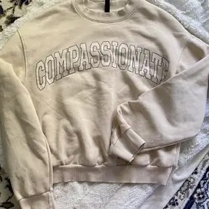 Beige sweatshirt med tryck på, jättefin och blir jättesnyggt ifall man har tillexempel en vit shorta under. Köpare står för frakt 