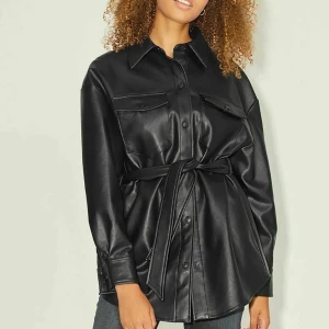 Skinkappa - Säljer nu denna super fina och coola skinkappa från Vero Moda i st M. Det är en super fin och bekväm vår jacka. Den är som ny då den aldrig är använt pgr av att den inte riktigt var min stil och för stor. Man kan använda den både som jacka och klänning!Första bilden är inte min!🤩💗