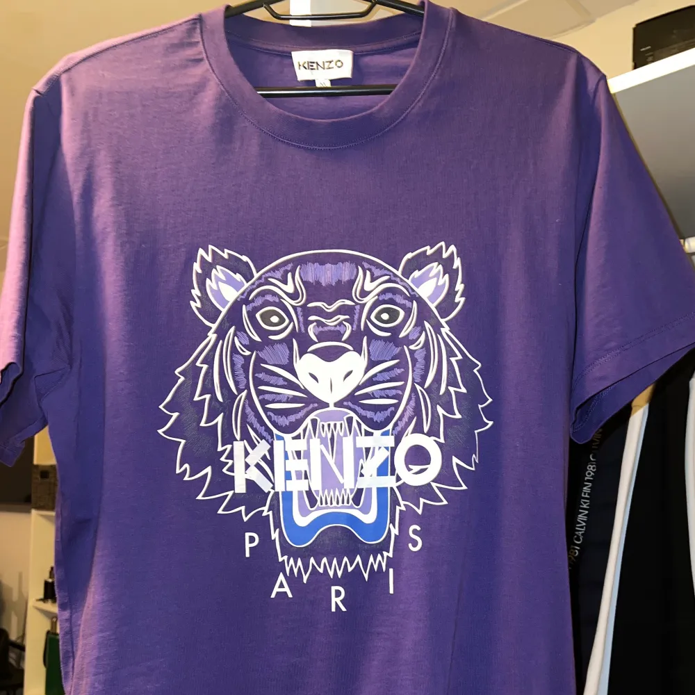 En lila kenzo t-shirt i storlek M. Köpt på NK förra sommaren och använts max 2 gånger. Säljer tröjan eftersom den inte kommer till användning. Kvittot kan eventuellt visas upp för äkthets bevis etc. Pris går att diskuteras.. T-shirts.