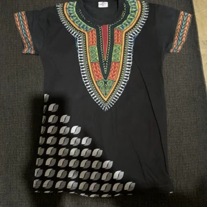 Custom made in Senegal  - Fin skön afrikansk T-shirt som köptes i Senegal där man fick välja mönster, så den är custom made. Strl är S och passar både killar och tjejer. Den är använd 2 ggr.