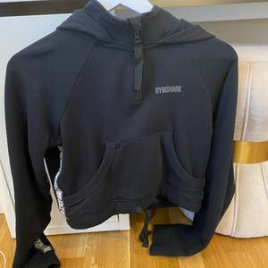 En svart croppad hoodie från Gymshark, knappt använd och jättefint skick. Storlek XS