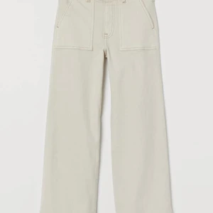H&M, Culotte high waist 32 - Ankellånga jeans i stretchig, tvättad denim från H&M. Hög midja och vida, raka ben. Ljusare beige färg. Nypris: 249 kr. Knappt använda. 