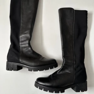 Svarta stövlar - Svarta stövlar köpta på sellpy. De är blandat läder och stretchigt material så de har ingen drag kedja och sitter tajt runt vaderna. De är i bra skick, behöver putsas upp bara :))