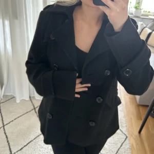 Svart kappa - Perfekta svarta vårkappan!💗 Köpt på Plick men kommer från H&M💕 Vet inte vilken storlek det är men jag är en s-m! Finns några slitningar i fodret på insidan men inget som syns!  