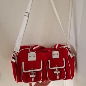 Väska - Röd och vit axelremsväska i begagnat men bra skick, inte mycke tecken på användning