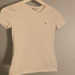 En Äkta vit Tommy Hilfiger t-shirt, helt oandvänd, inga fläckar, äkta märke och i storlek xxs men funkar för XS🤍säljer denna eftersom att jag rensar min garderob och har helt enkelt inte plats för den, orginal pris är 499 kr men säljer för 189 kr 🤍