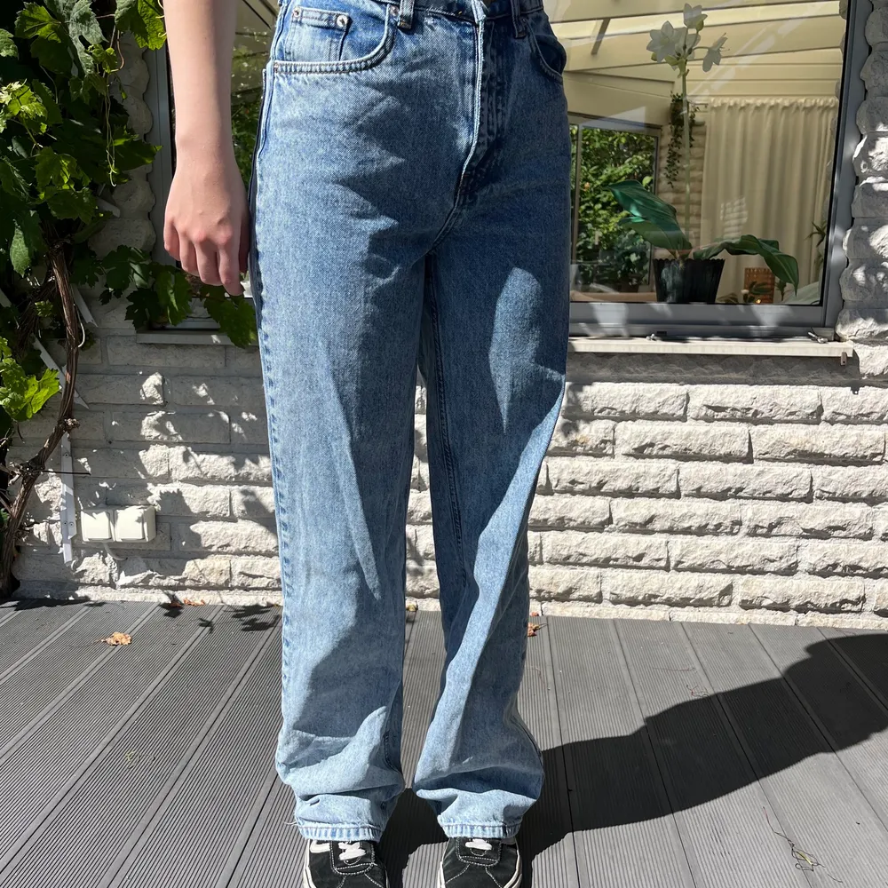 Blå jeans ifårn NA-KD med slitningar nedtill. Bra skick. Passar någon som är runt 165cm lång om man vill att dom ska sitta som på bilden! Köparen står för frakten🫶🏻. Jeans & Byxor.