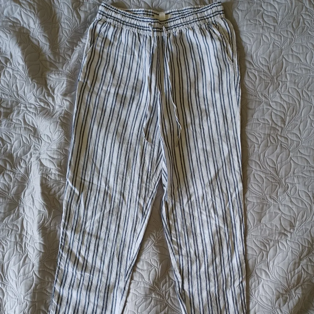 Vita och blå/gråa randiga byxor med snören som är väldigt sommarliga.  Varan kostar 75kr och frakten kostar 39kr.. Jeans & Byxor.
