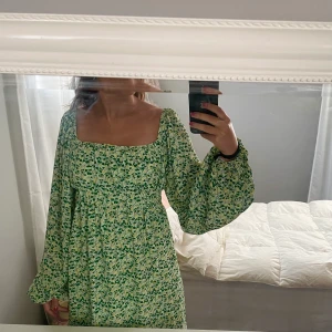 Grön sommarklänning - Underbar grön klänning med blommor från NA-KD… Endast använd 1 gång och är i nyskick💓 Säljes pågrund av att den är lite för stor för mig.