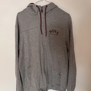 Hugo Boss hoodie - Grå hugo boss hoodie. Mycket fint skick inga skador så vitt jag vet. Nypris va 2000 kr. Sitter som en L i storlek.