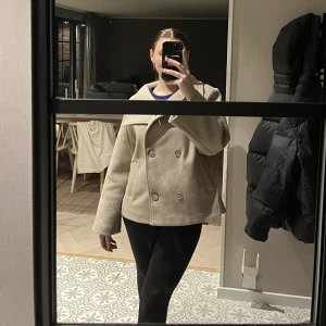 Kort kappa - Säljer nu världens finaste kappa från bubbleroom! Säljer pga att den inte kommit till så mycket användning, använd ett fåtal gånger så är som nyskick! Färgen är beige och passar till allt, den är även heeelt slutsåld💖 Frakt tillkommer!