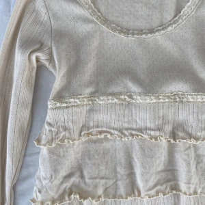 Pointelle topp med volanger  - Vacker topp från Kaffe i pointelle mönster med volanger och spets detaljer. Size M. Köps via Swish eller köp nu 💋