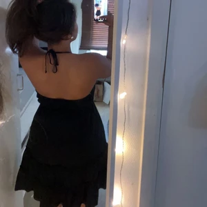 Svart somrig klänning  - En jätte fin svart somrig klänning! Man kan knyta mellan brösten och det är som små volanger längst ner vid själva klänningen. Knyte vid nacken som man kan justera och bra passform. Storleken är S! ☀️☀️