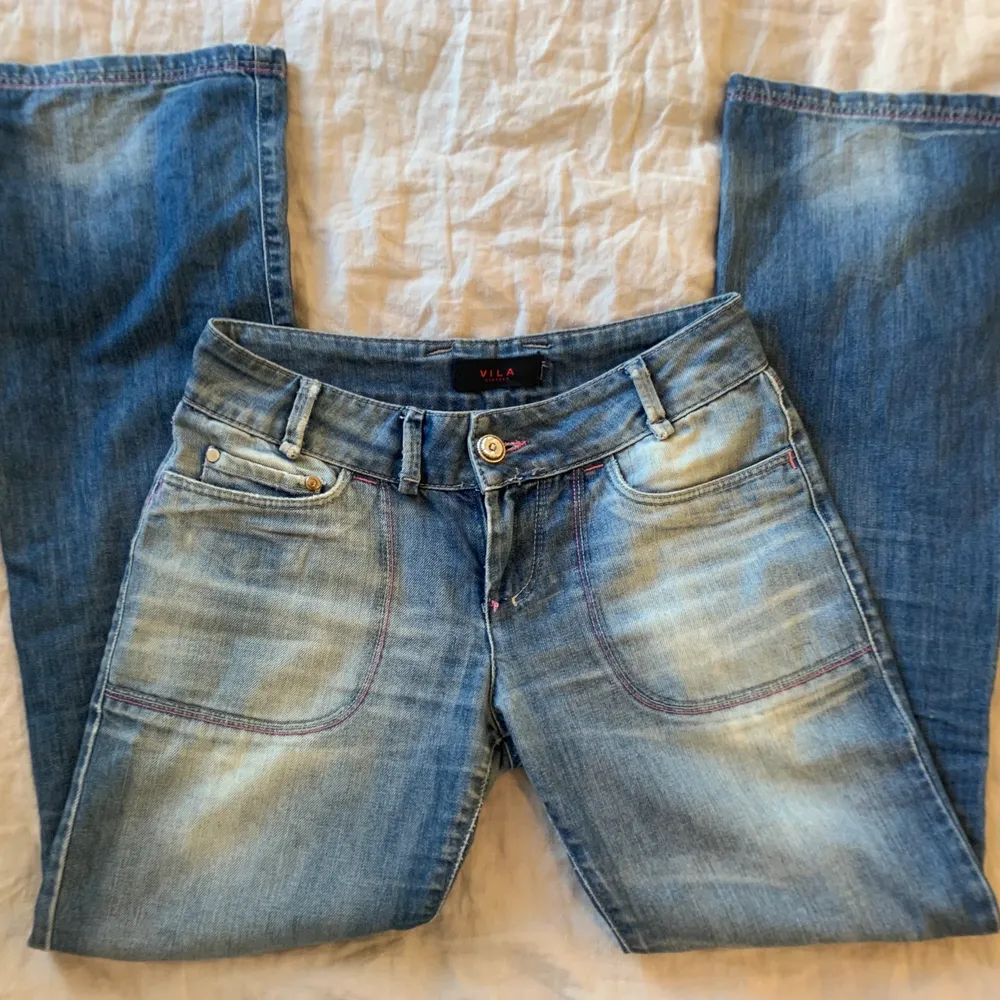 Assnygga lågmidjade jeans från Vila! Bootcut med rosa sömmar och gullig knapp. Waist 27/ St S. Har tyvärr ett litet hål i grenen, därav priset. Midjemått 28 och ytterbensmått 102 . Jeans & Byxor.
