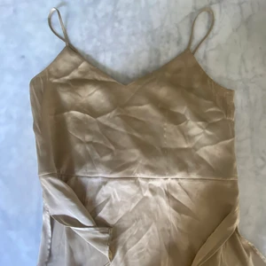 Silkeslinne - Silkeslinne från ARKET storlek 34. Figursydd och små slitsar nedtil. Väldigt  LITEN i storleken,  passar de med mindre byst.