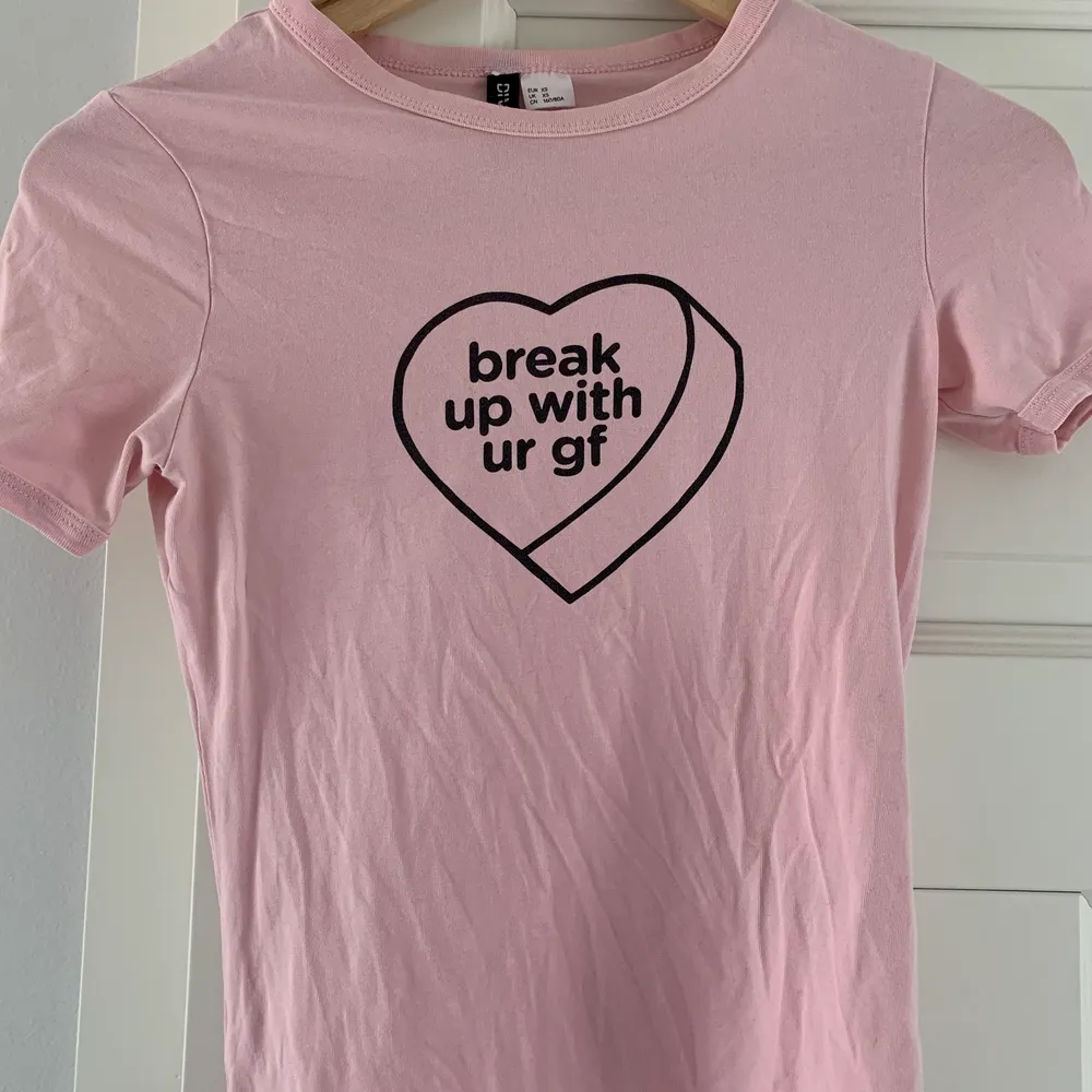 Ljusrosa T-shirt med tryck ”Break up with ur gf”. Från H&Ms kollektion med Ariana Grande. Köpt 2019, väl använd men har mer att ge! Inga defekter. Skriv om du vill ha fler bilder! 💞💞. T-shirts.