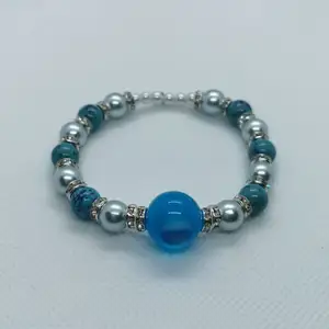 Somrigt armband med vackra blå pärlor. 18 cm med stretch. Frakt ingår I priset 