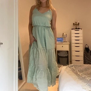 Långklänning - Superfin ljusgrön långklänning från Weekday. Superbra skick och går att styla på olika sätt genom att knyta midjebandet olika. Jag är 177 cm för längdreferens. 