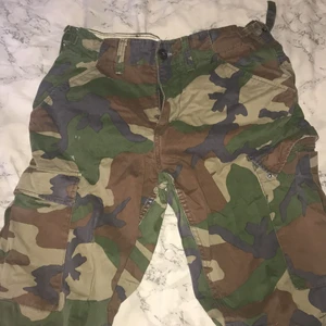 Cargo byxor  - Cargo byxor med fickor på benen och bak i camouflerings mönster 