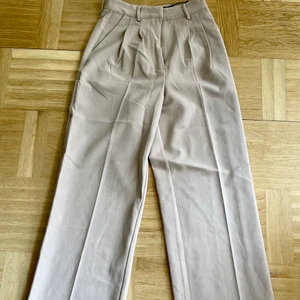 Kostymbyxor med väck  - Snygga kostymbyxor med väck längst benen i tjockare, strechigt material. 