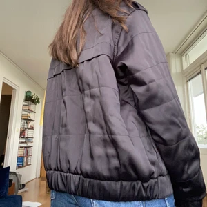 Svart bomberjacka i sidenliknande material strl 38 - Svart bomberjacka i lent material, liknar siden. Från h&m, storlek 38. Väl använd men väldigt snygg ❤️‍🔥