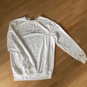Vit sweatshirt med text - Vit tröja med texten ”C’est la vie, Paris”. Supermjuk